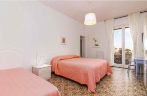 a white bedroom with two beds and a window at Casa Mansi in Scala