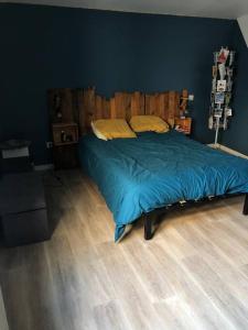 a bedroom with a bed with a wooden headboard at Comme à la maison in Marsan