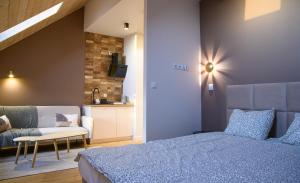a bedroom with a bed and a couch and a table at Winnica Strzegocice SPA in Bielowy