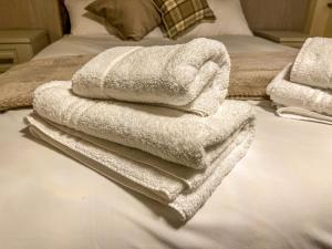 a pile of towels sitting on top of a bed at Grant House in Boston