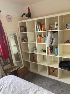 a room with white book shelves and a bed at Comfortable rooms upstairs at number 8 