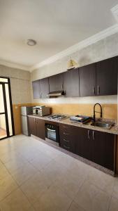 a large kitchen with brown cabinets and a sink at Résidence Belle Vue 6 in Marrakesh