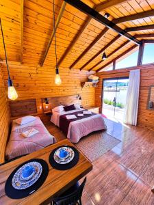 a bedroom with two beds and a table in a room at Cabanas Rural Colina Do Sol in Cambará
