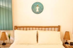 ein Schlafzimmer mit einem Bett mit einer blauen Platte an der Wand in der Unterkunft Suites da Loja Caraíva in Porto Seguro