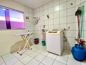 Baño de azulejos blancos con lavabo y aseo en Apto espaçoso no Centro, térreo com 2 Quartos de Casal ArCond WiFi 400megas HomeOfice Cozinha e Garagem, en Dourados 9 fotos más