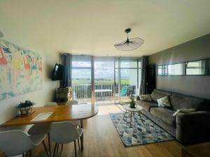 a living room with a couch and a table at Appartement Belles Vacances in Quiberon