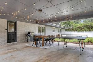 un patio con mesa de ping pong y sillas en Cozy - Organic Modern - Bungalow - FSU, en Tallahassee