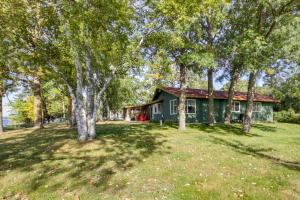 a green house with trees in front of it at Lakefront Walker Home with Boat Dock and Lift! in Walker
