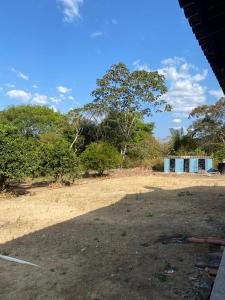 a dirt field with trees and a building in the background at Valle dos ipês in Tianguá