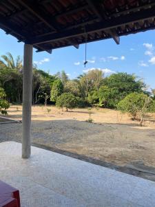 a porch with a view of a field and trees at Valle dos ipês in Tianguá