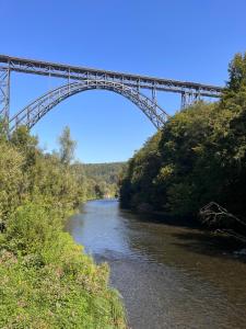 een brug over een rivier naast een rivier bij Ferienwohnungen Waldblick in Remscheid