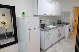 cocina blanca con nevera y mesa en דירת אירוח vip רק 5 דקות נסיעה מהים חלום של מקום, en Ashkelon 35 fotos más