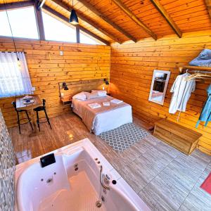 een slaapkamer met een bed en een bad in een kamer bij Cabanas Rural Colina Do Sol in Cambará