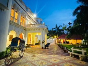 a building with a horse drawn carriage in front of it at Chola Heritage Resort in Kāraikkudi