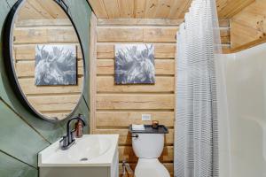 a bathroom with a toilet and a sink and a mirror at Peaceful Whitley City Cabin on 10 Wooded Acres! in Whitley City +23 photos
