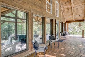 a screened in porch of a house with glass windows at Peaceful Whitley City Cabin on 10 Wooded Acres! in Whitley City