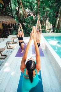 um grupo de mulheres a fazer ioga junto a uma piscina em Terasu Riviera Maya Hotel & Spa, en Xcaret em Playa del Carmen