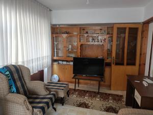 ein Wohnzimmer mit einem Sofa und einem TV in der Unterkunft Bahçeli Müstakil Daire in Burhaniye