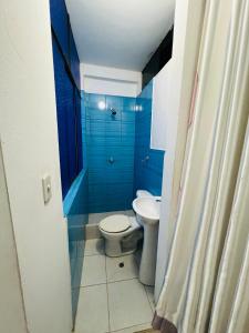 een blauwe badkamer met een toilet en een wastafel bij La casa de Elena in Tingo María