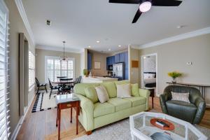 a living room with a green couch and a kitchen at Greensboro Condo Rental Near Hospital and Trails! in Greensboro