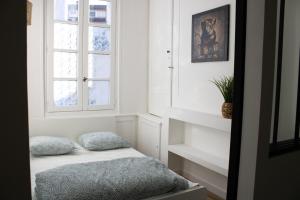 Cette petite chambre comprend un lit et une fenêtre. dans l'établissement La Galerie de Lumière 201, à Aurillac