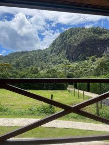 a view of a mountain through a fence at Chalé Floresta Mauá in Resende +32 photos