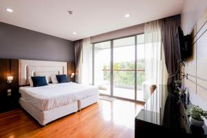 una camera da letto con un letto e una grande finestra di The Regent Bangtao Apartments gorgeous view of the jungle a Bang Tao Beach Altre 51 foto