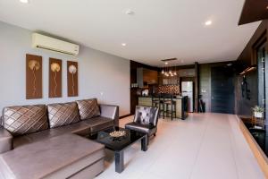 un soggiorno con un divano e un tavolo di The Regent Bangtao Apartments gorgeous view of the jungle a Bang Tao Beach