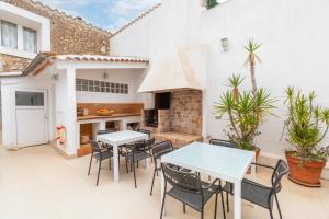 eine Terrasse mit Tischen und Stühlen sowie eine Küche in der Unterkunft Mallorca Can Florit in Sencelles