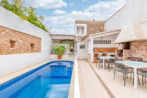 an outdoor swimming pool with a table and chairs and a house at Mallorca Can Florit in Sencelles