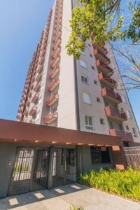 a tall apartment building with a large building at Apto Style PUC in Porto Alegre