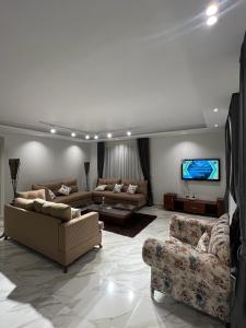 a living room with two couches and a flat screen tv at Villa Marina 6 First Row on The Lake in El Alamein