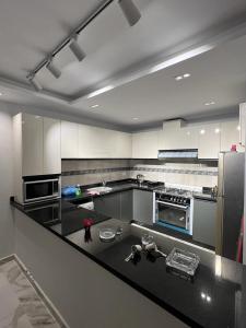 a large kitchen with a black counter top at Villa Marina 6 First Row on The Lake in El Alamein