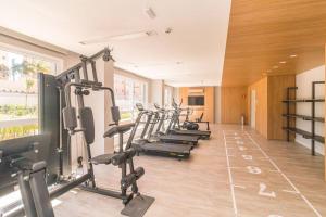 a gym with a row of treadmills and machines at Apto Style PUC in Porto Alegre