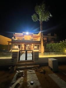 una casa con una palma di fronte di Villa Marina 6 First Row on The Lake a El Alamein