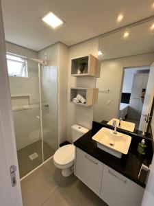 a bathroom with a toilet and a sink and a shower at Loft próximo a Vila Germânica 604 in Blumenau