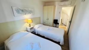 a hotel room with two beds and a mirror at Charming triplex T2 in the Old Village Vilamoura in Quarteira