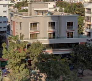 um edifício branco com árvores em frente em Greenstones Boutique Hotel em Nashik