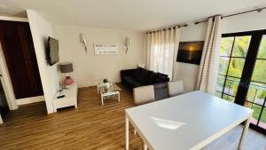 a living room with a white table and a couch at Charming triplex T2 in the Old Village Vilamoura in Quarteira