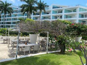 a patio with tables and chairs in front of a building at Aria Ocean Beach 715A QueridaEstancia in Bucerías