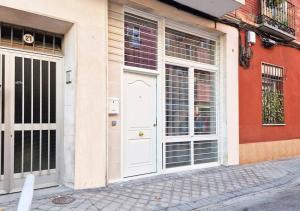 a white door on a building with windows at Apartamento Altimiras 'Las Ventas' in Madrid