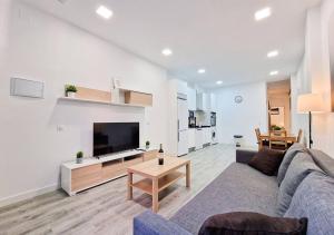 ein Wohnzimmer mit einem Sofa und einem TV in der Unterkunft Apartamento Altimiras 'Las Ventas' in Madrid
