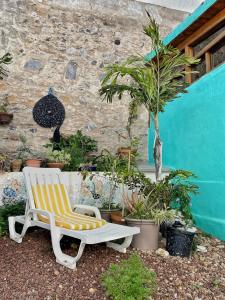 una silla amarilla y blanca sentada frente a un edificio en Cozy Studio en Casa con Encanto, en Caleta de Interián