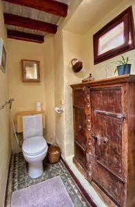 baño con aseo y puerta de madera en Cozy Studio en Casa con Encanto, en Caleta de Interián