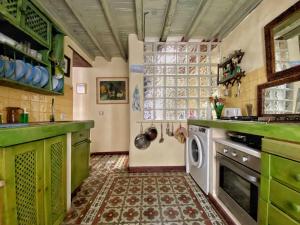 a kitchen with green cabinets and a washing machine at Cozy Studio en Casa con Encanto in Caleta de Interián