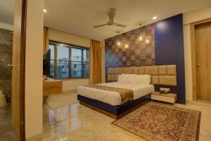 a bedroom with a king sized bed and a bathroom at Greenstones Boutique Hotel in Nashik