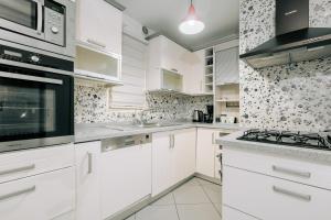 伊斯坦堡的住宿－Sleek and Central，白色的厨房配有白色橱柜和电器