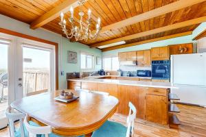a kitchen with a wooden table and a white refrigerator at Sea Mist in Rockaway Beach