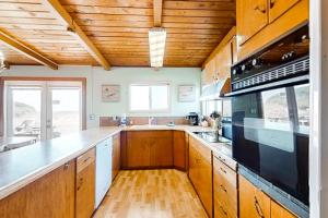a kitchen with wooden cabinets and a stove top oven at Sea Mist in Rockaway Beach