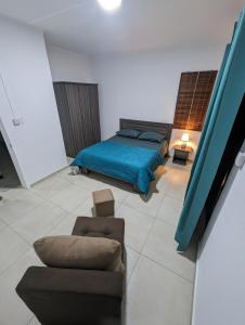 a bedroom with a bed and a couch and a chair at Blissful Abode GV in Grand Gaube